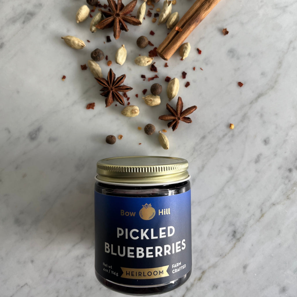 Jar of 'Pickled Blueberries' with spices on a marble surface
